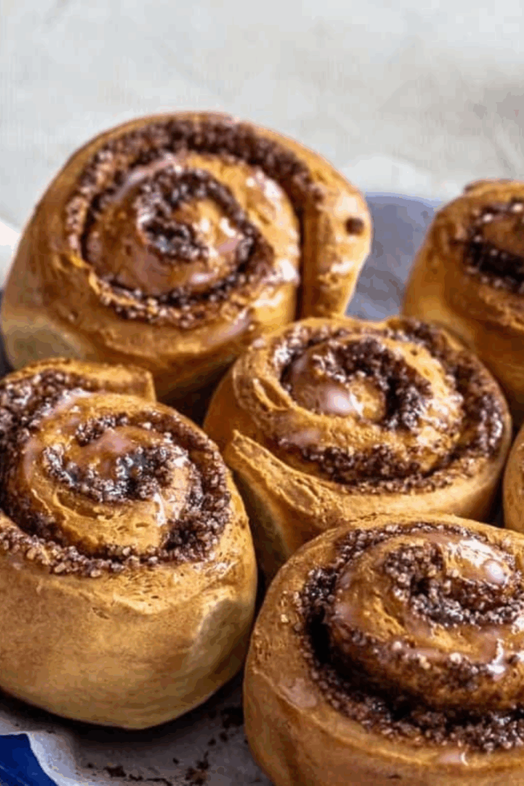 Golden, fluffy homemade cinnamon rolls topped with rich cream cheese frosting.