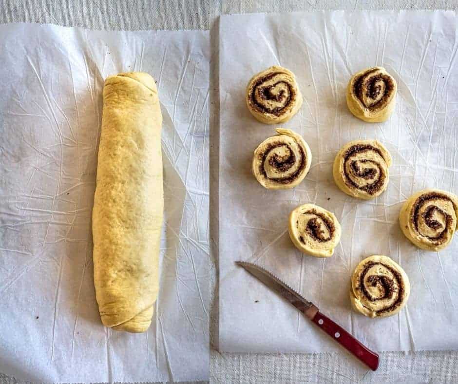 Rolling cinnamon dough into a tight log and slicing into even rolls with a sharp knife.