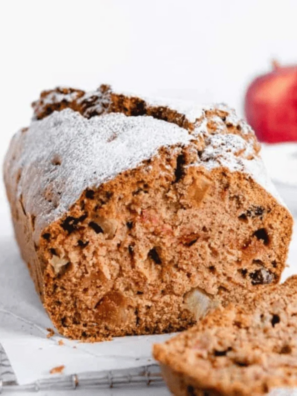 Sliced air fryer apple cranberry bread on a wooden board with fresh cranberries
