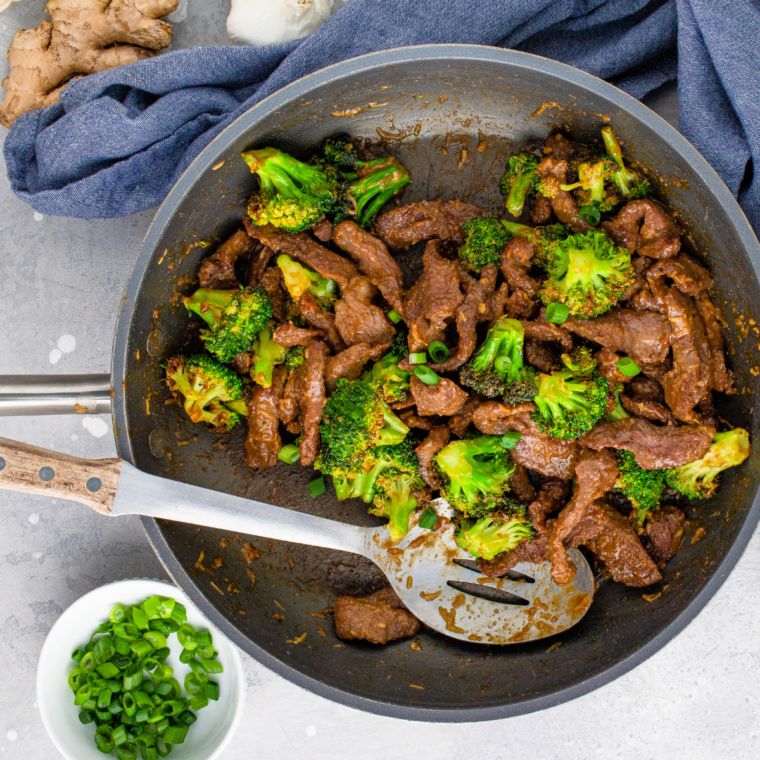 Whisked sauce ingredients in a small bowl, then combined with cooked beef and broccoli in a skillet, thickened and served with scallion garnish.