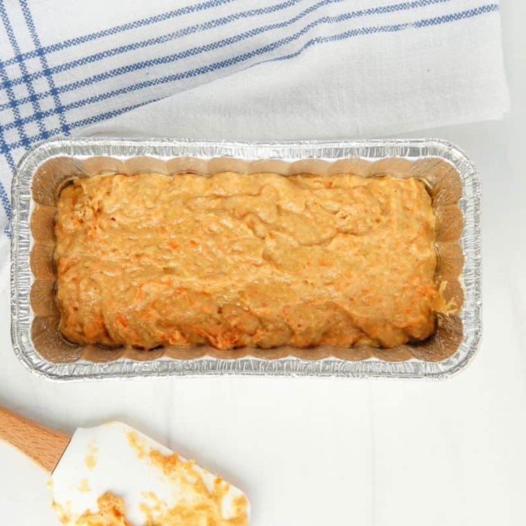 Toothpick being inserted into the center of a carrot cake in the air fryer, testing for doneness after 25 minutes of cooking.