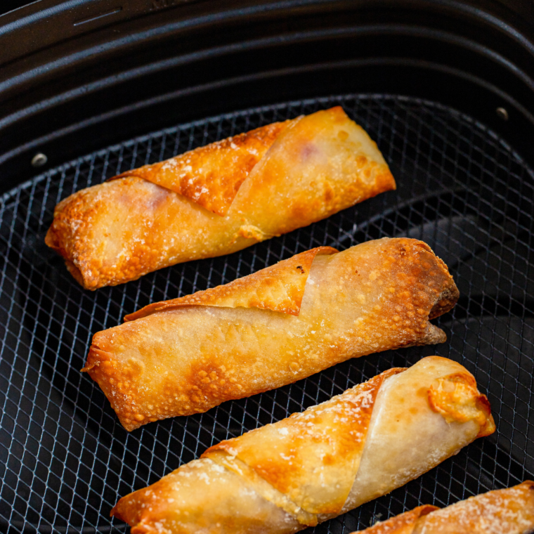 Air fryer ham and pickle egg rolls served with dipping sauces on a serving board
