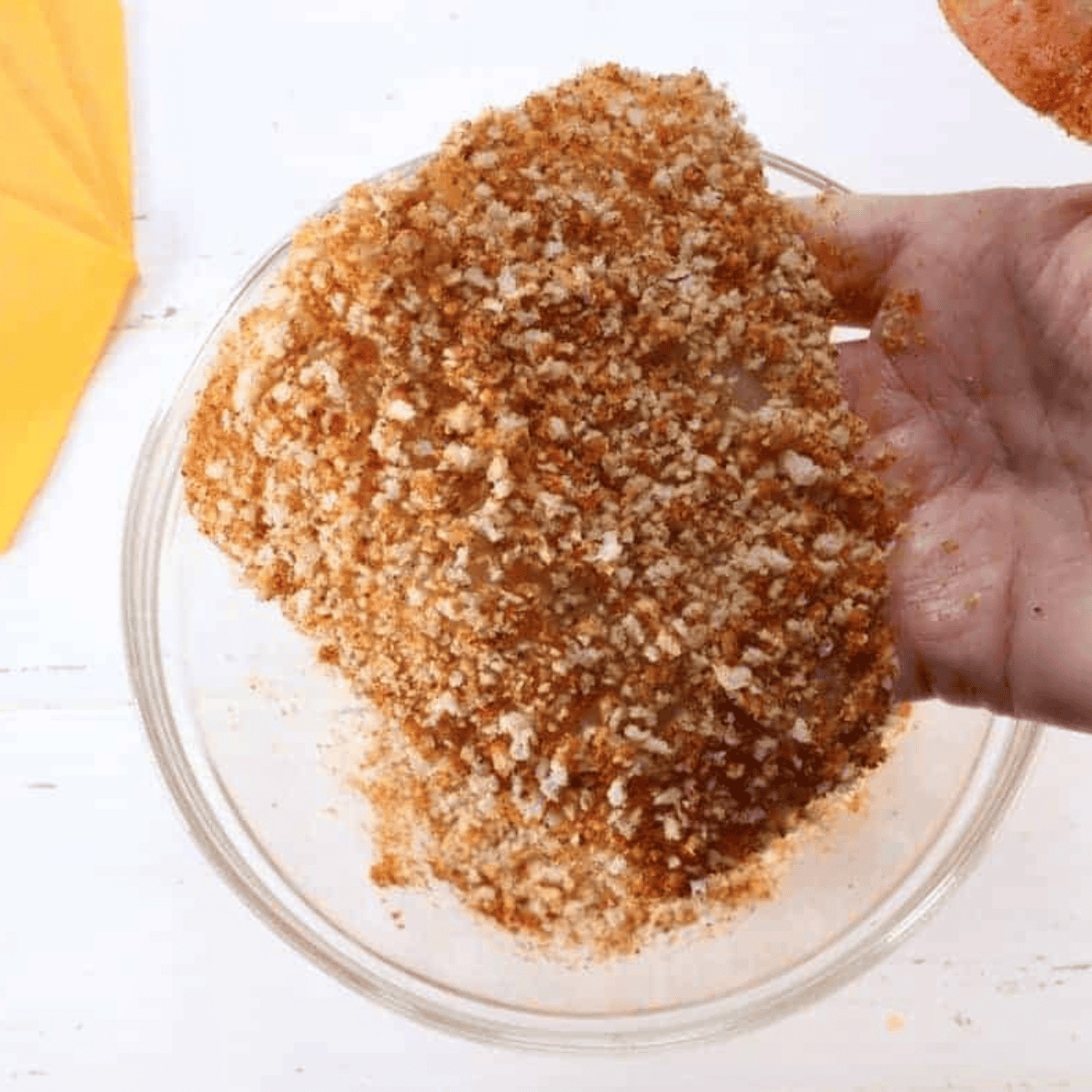 Dipping fish fillets into beaten egg on both sides, then coating them with the breadcrumb mixture.