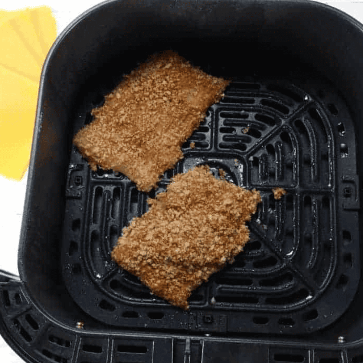 Spraying the air fryer basket with cooking spray, placing breaded fish fillets inside, and spraying the fish with cooking spray before cooking at 350Β°F for 10-12 minutes, flipping halfway.