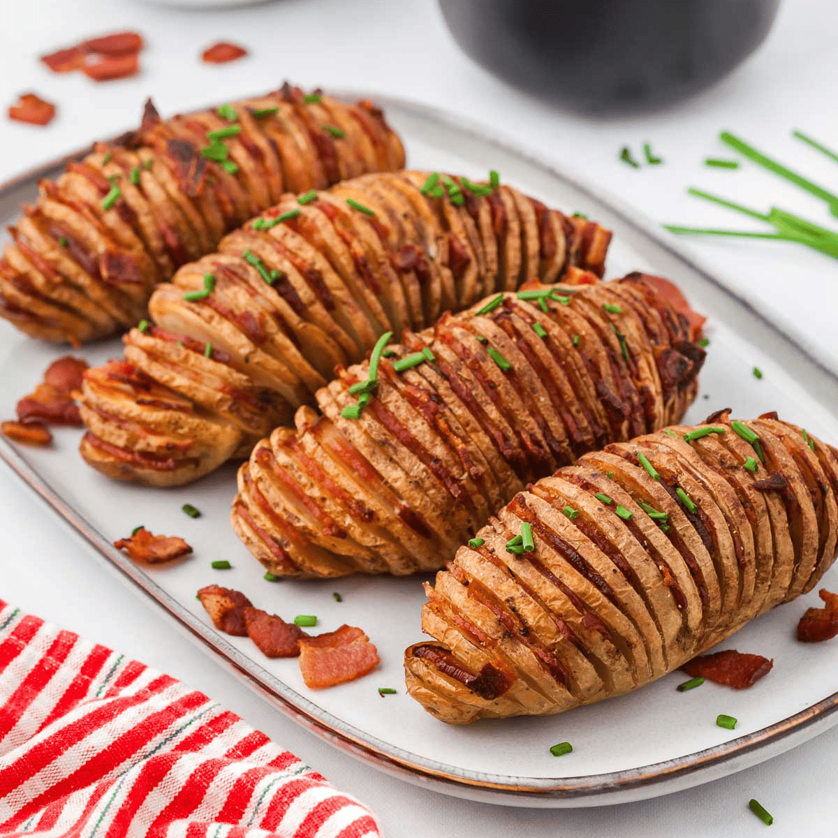 Golden-brown, crispy Hasselback potatoes being removed from the air fryer.