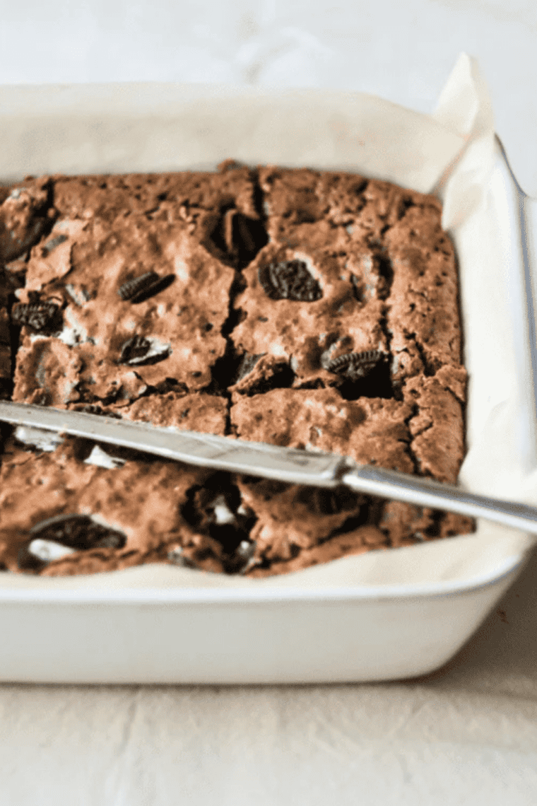 Plate of fudgy air fryer Oreo brownies topped with crushed Oreo cookies and chocolate chunks served as rich dessert squares with gooey center