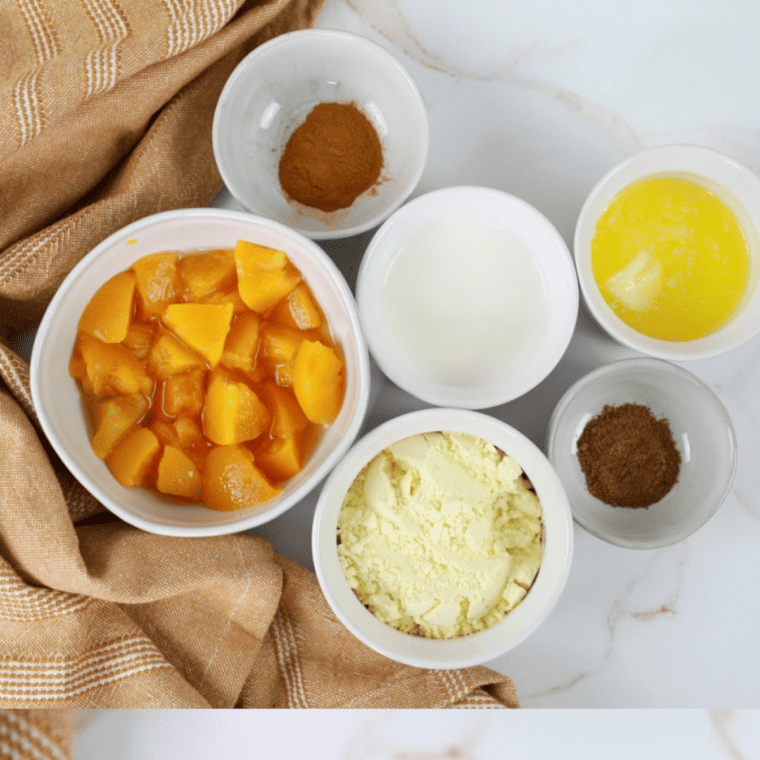Ingredients needed for Air Fryer Peach Cobbler Mug Cake on kitchen table.