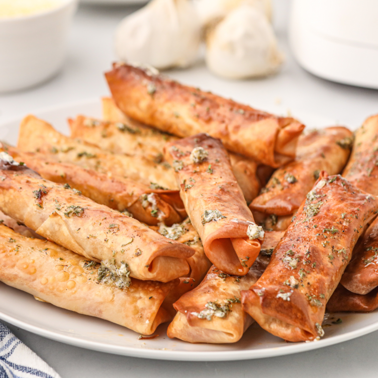 Golden brown homemade pizza egg rolls cut in half showing melty mozzarella and pepperoni filling