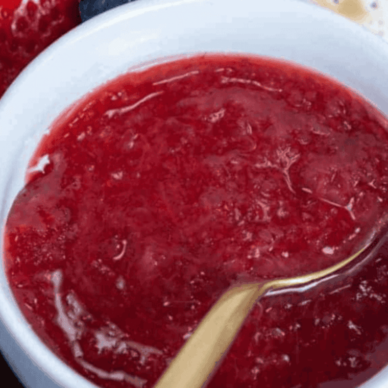 Homemade Cracker Barrel copycat strawberry jam in a jar with fresh strawberries.