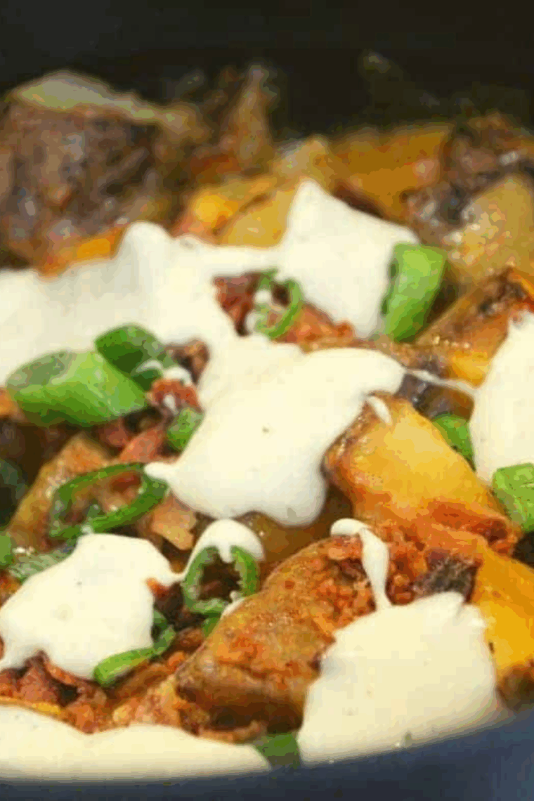 Loaded Ninja Foodi potatoes with melted cheese, bacon, and sour cream