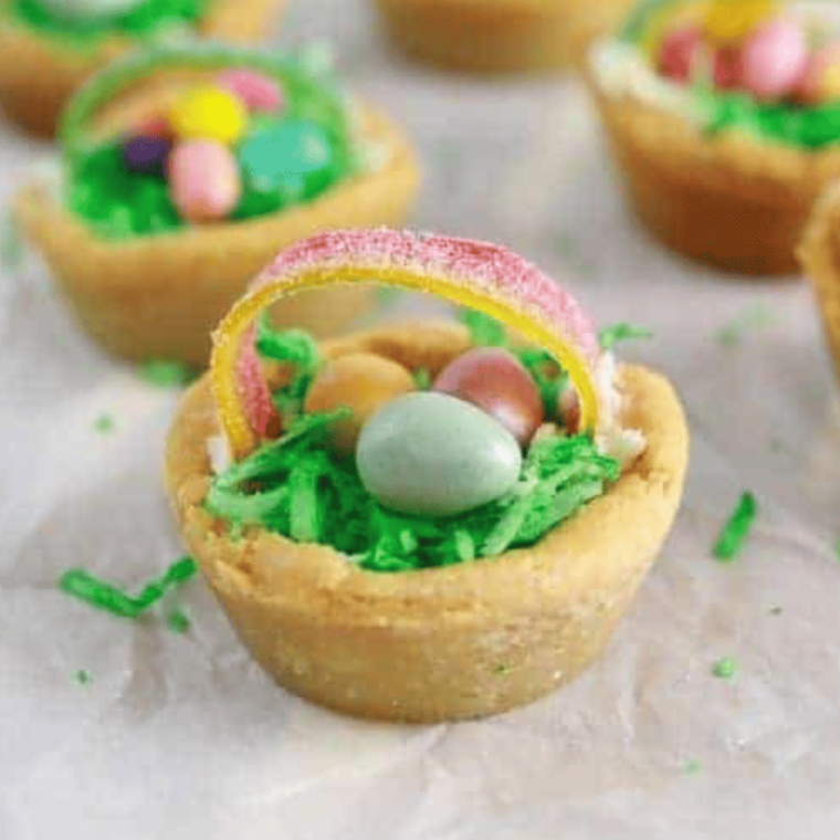 Air fryer Easter basket cookie cups filled with colorful candy and decorations.