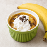 Air fryer banoffee pie in a white ramekin topped with whipped cream and chocolate shavings