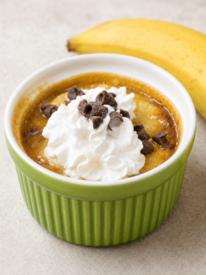 Air fryer banoffee pie in a white ramekin topped with whipped cream and chocolate shavings
