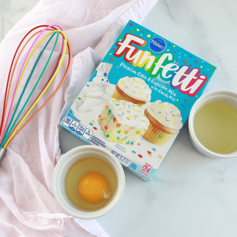 Funfetti cake mix, eggs, oil, and glaze ingredients on a counter