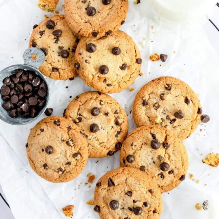 Freshly baked Air Fryer DoubleTree Cookies stacked on a plate with melted chocolate chips and chopped walnuts.