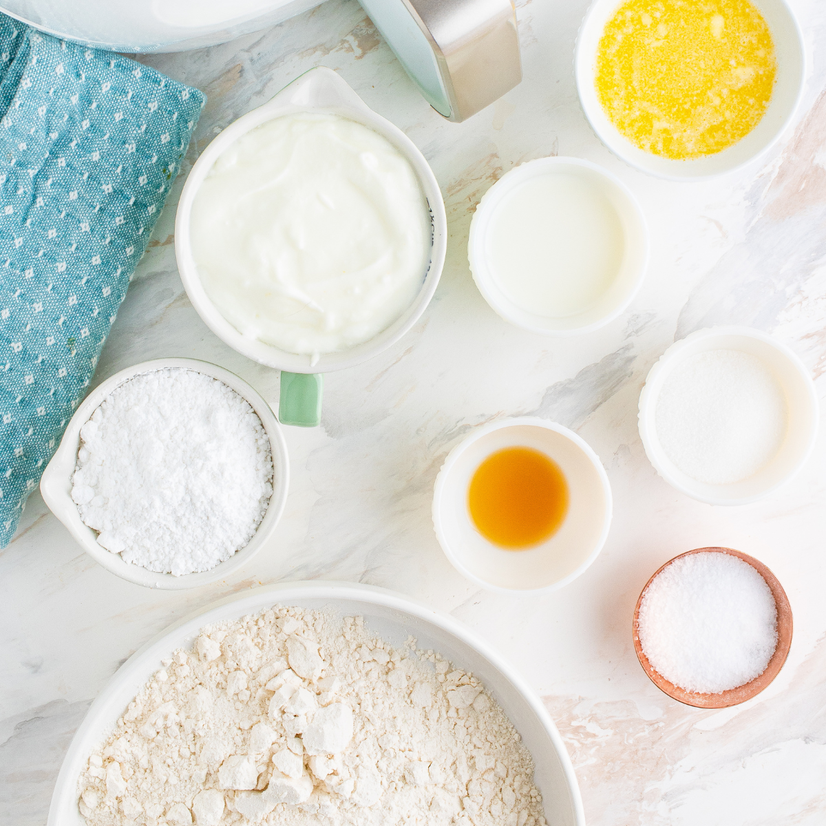 Ingredients for air fryer copycat Krispy Kreme donuts including self-rising flour, Greek yogurt, sugar, powdered sugar, and butter on a kitchen counter