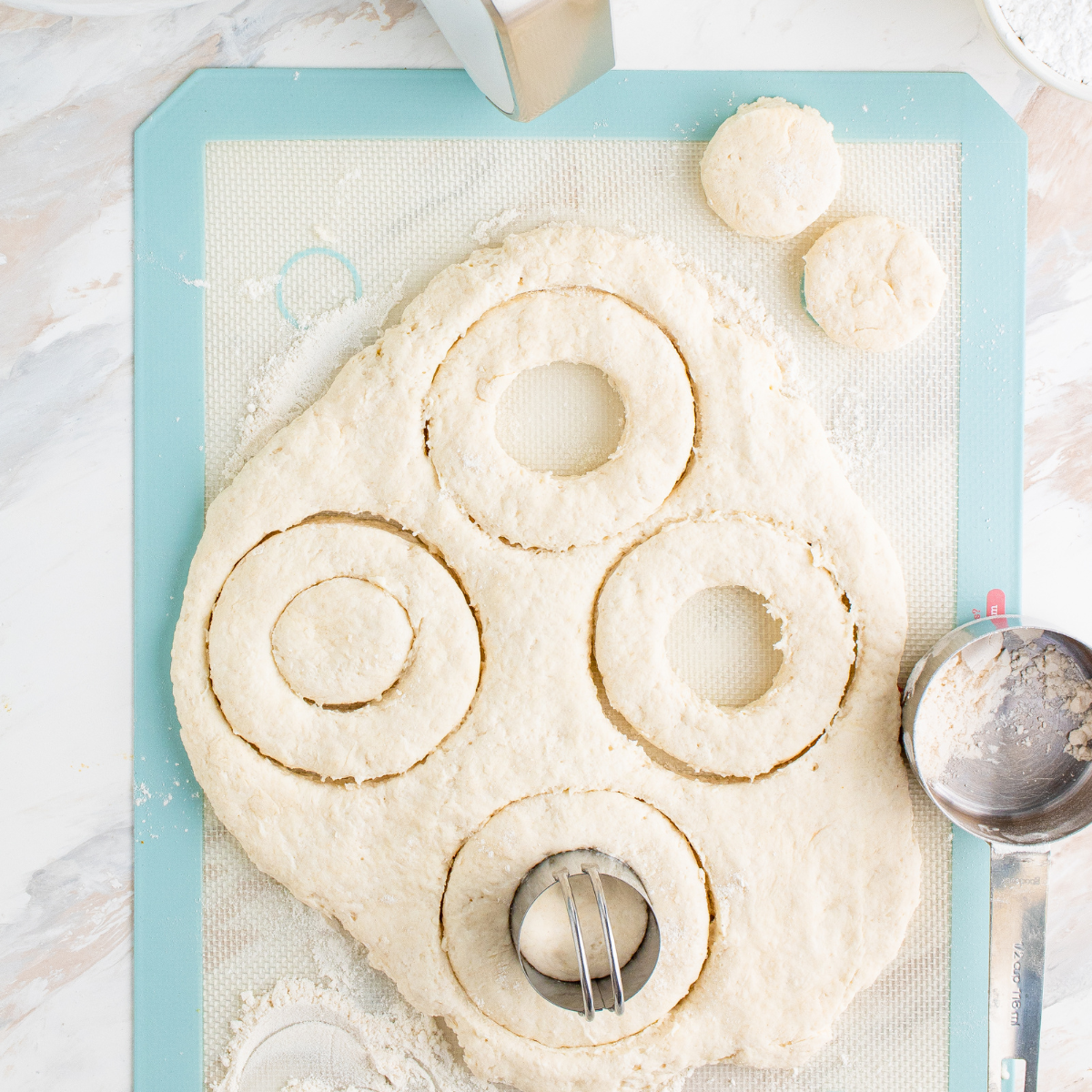 Krispy Kreme copycat donut dough rolled out on a floured wooden surface ready to cut