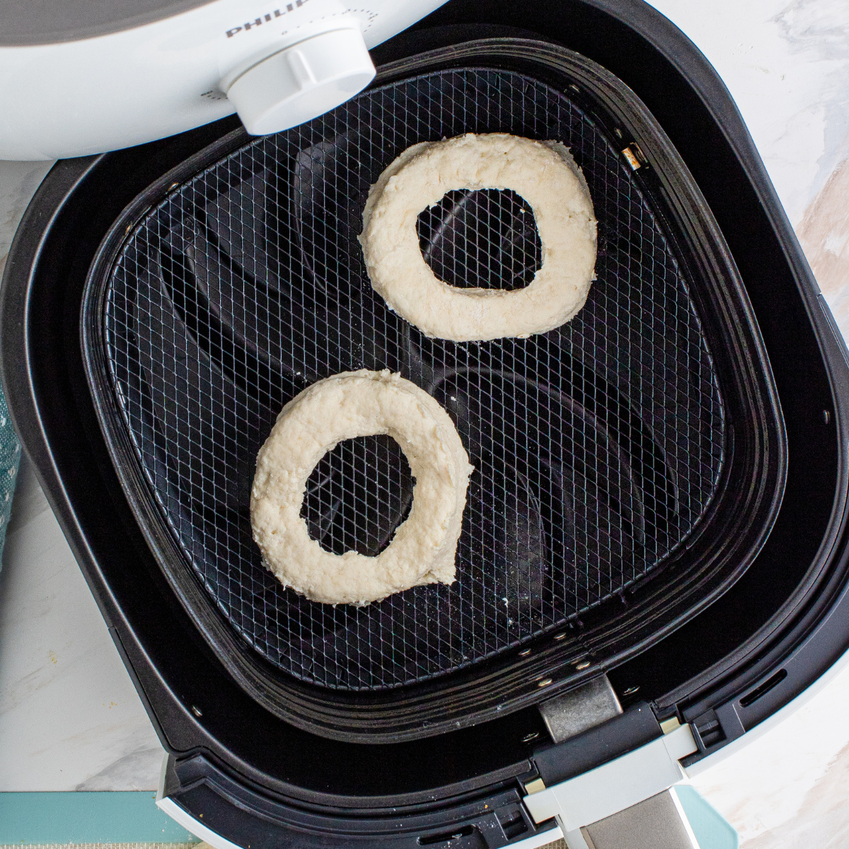 Golden brown air fryer copycat Krispy Kreme donuts in the basket fresh from cooking