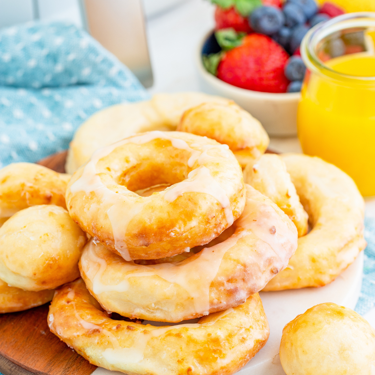 Air fryer copycat Krispy Kreme donuts on a cooling rack with shiny vanilla glaze dripping down the sides