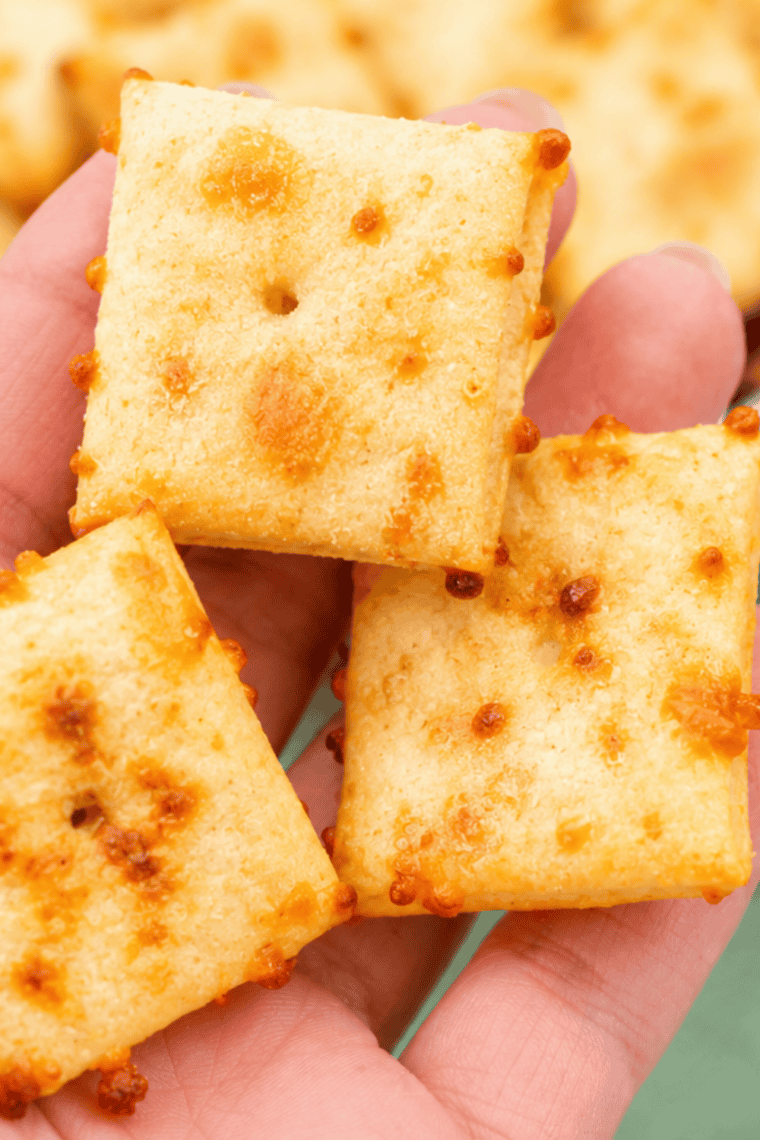 Close-up of homemade air fryer Cheez-Its showing crispy golden edges and the poked center hole