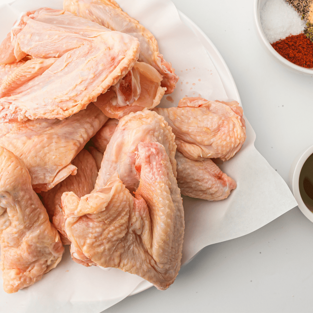 Ingredients for air fryer buffalo chicken wings — wings, flour, butter, seasonings and buffalo sauce.