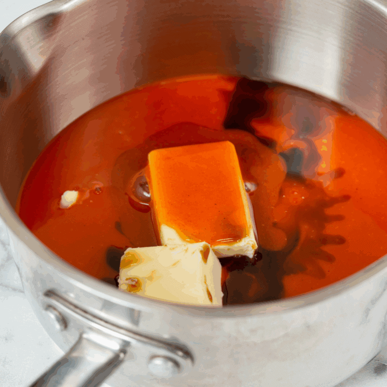 Hooters-style buffalo sauce made with butter and hot sauce in a small saucepan.