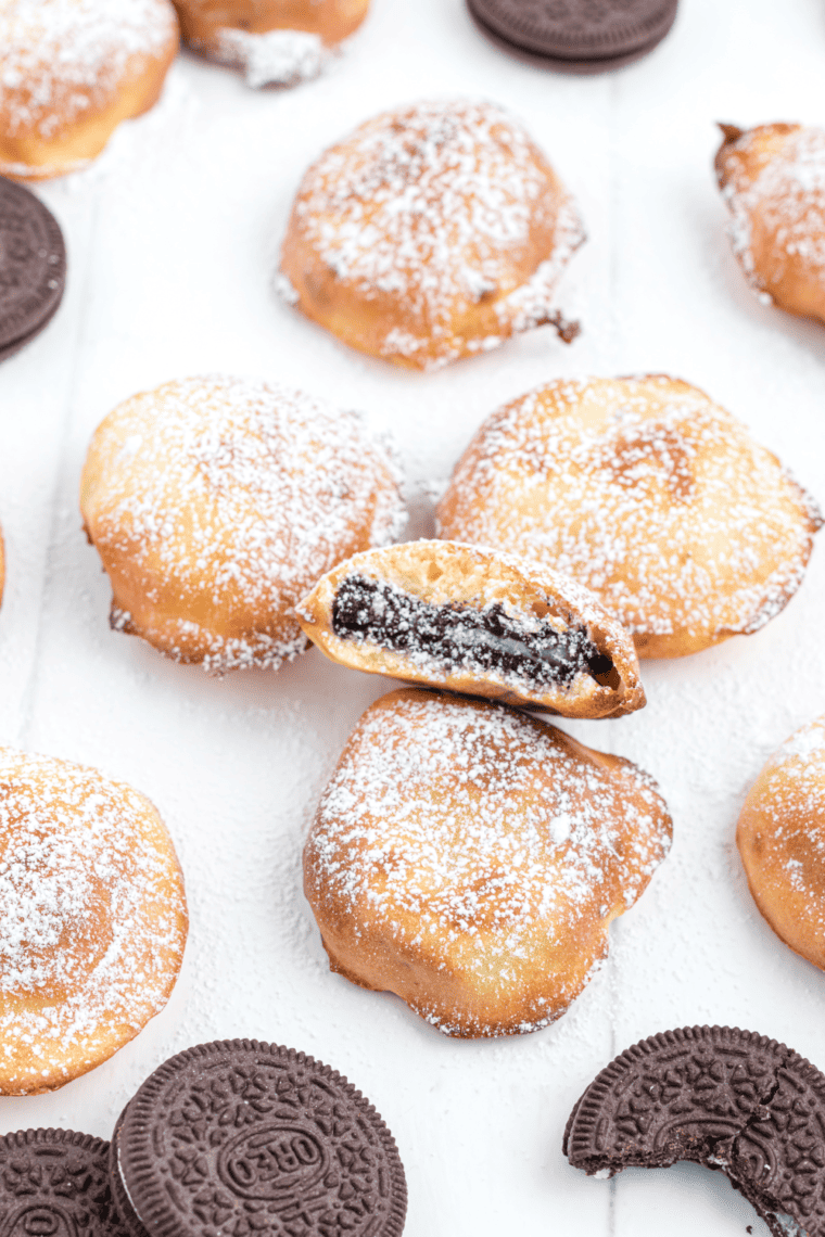 Golden air fried Oreos coated in pancake batter, served on a plate.