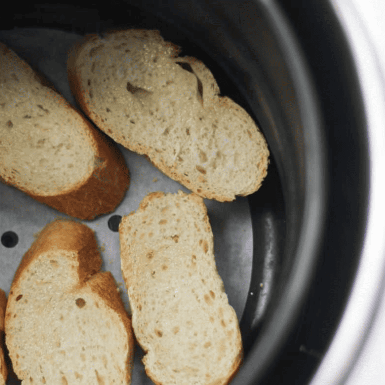 Golden, crisp toasted baguette slices cooling on a wire rack after air frying