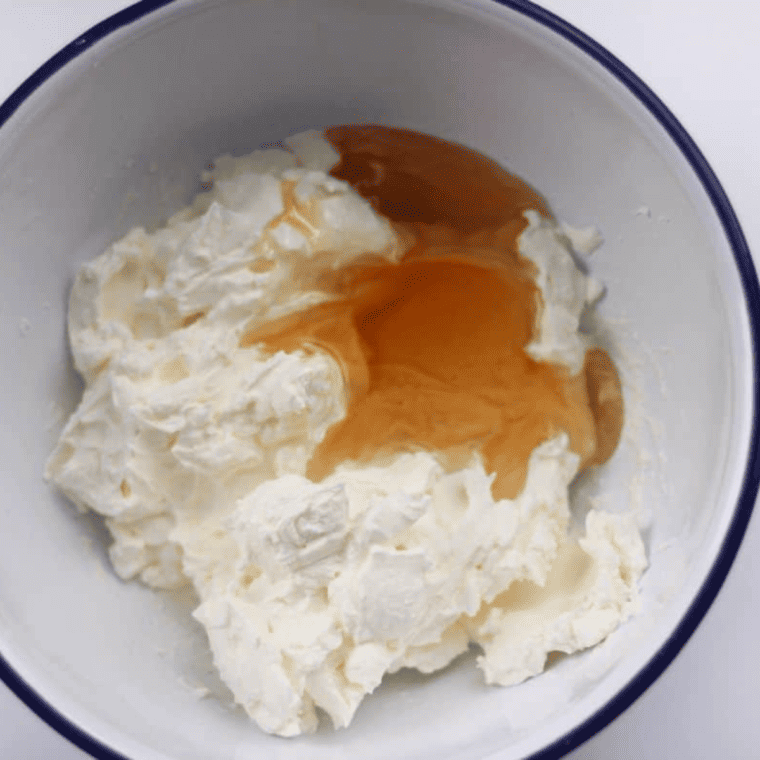 Mascarpone cheese mixed with honey in a small bowl until smooth and spreadable