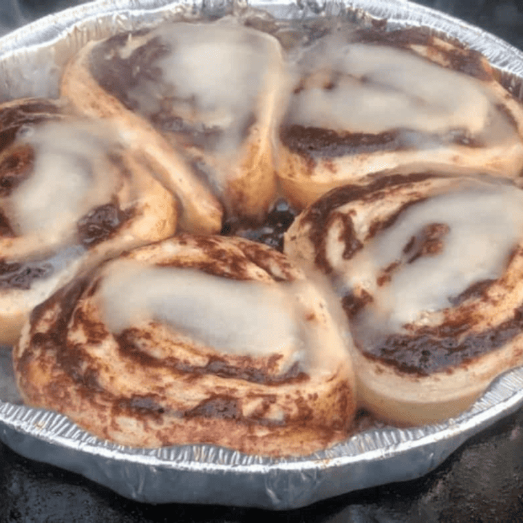 Spatula flipping golden cinnamon rolls cooking on the Blackstone griddle