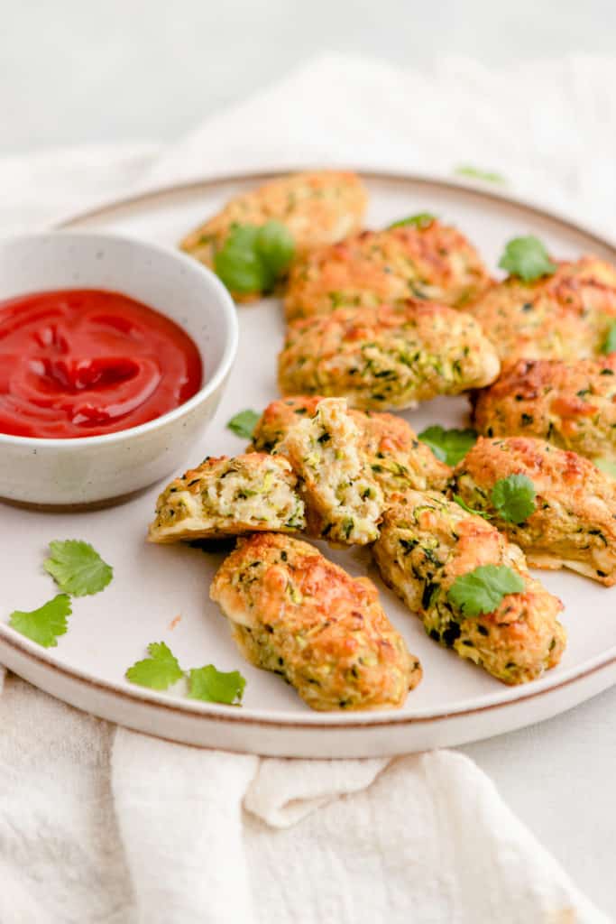 Crispy air fryer zucchini tots served on a plate with dipping sauce, ready to enjoy.