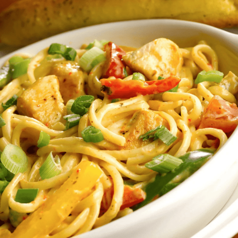 Instant Pot Chicken Fajita Pasta served in a bowl with creamy sauce, chicken strips, bell peppers, and pasta coated in fajita seasoning.