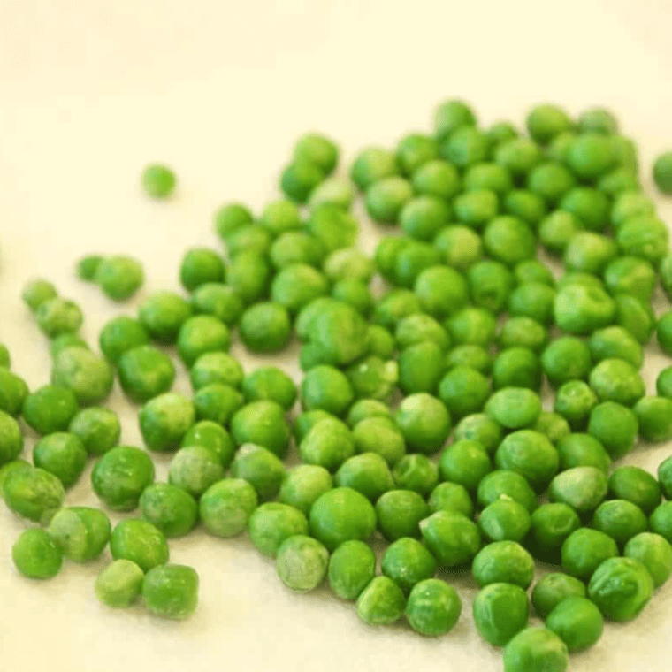 Frozen peas spread out on a kitchen towel to dry for 10-15 minutes.