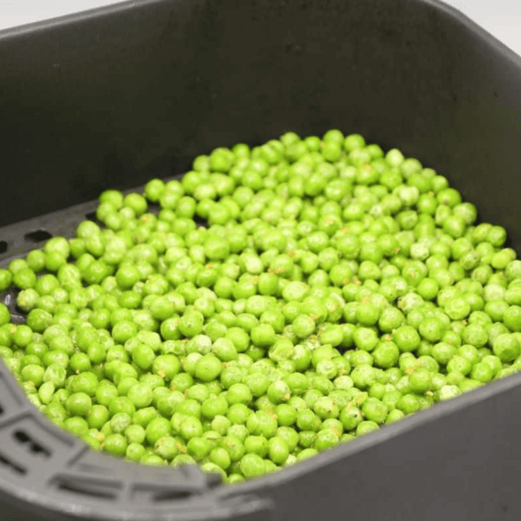 Preheating air fryer to 350°F and spreading peas evenly in the basket, shaking occasionally during cooking.