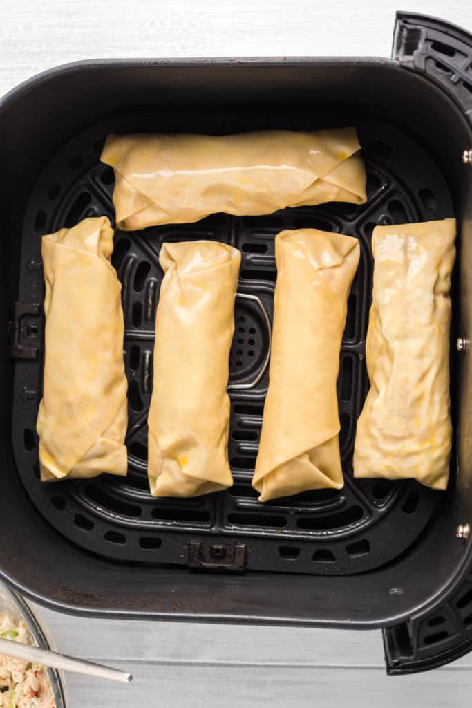 Crab Rangoon Egg Rolls in the air fryer basket.