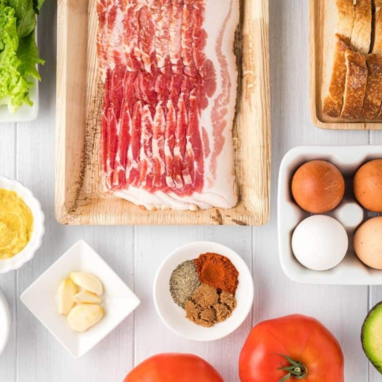 Ingredients for an air fryer BLT: bacon, lettuce, tomato, bread and mayonnaise