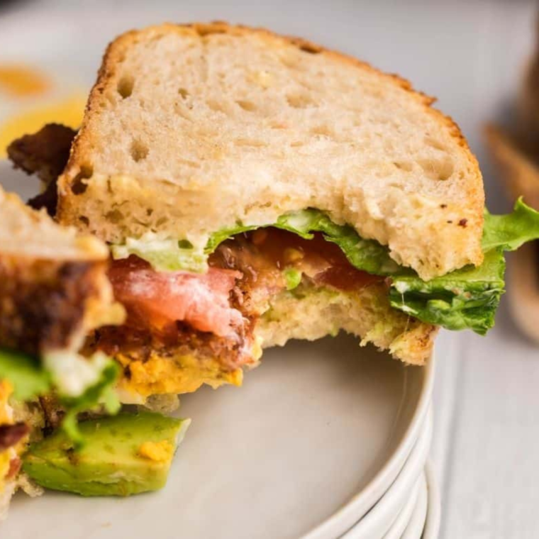 Assembled air fryer BLT topped with bacon, lettuce, tomato and avocado