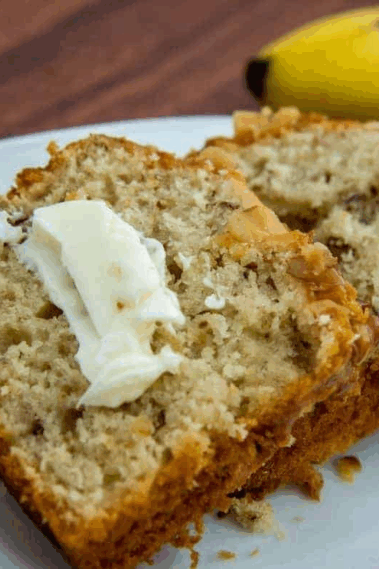 Air fryer banana walnut pound cake sliced with golden crust and walnut topping.
