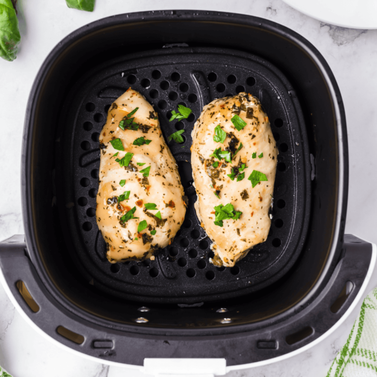 Finished marinated chicken breasts on a cutting board, ready to cook