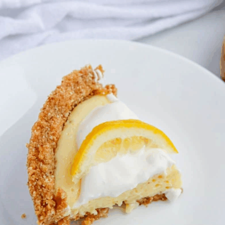 Air fryer lemon pie with golden crust and creamy lemon filling, sliced on a plate.