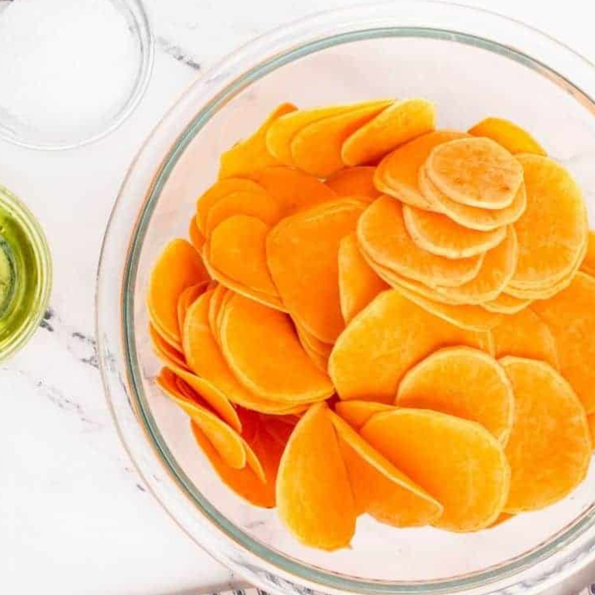 Slicing sweet potatoes thinly for air fryer sweet potato chips.
