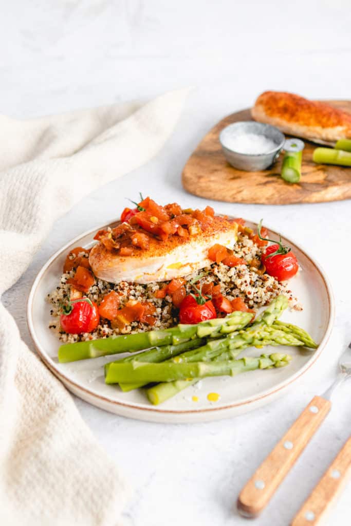Plated Easy Air Fryer Tuscan Chicken with creamy sun-dried tomato sauce and fresh herbs.