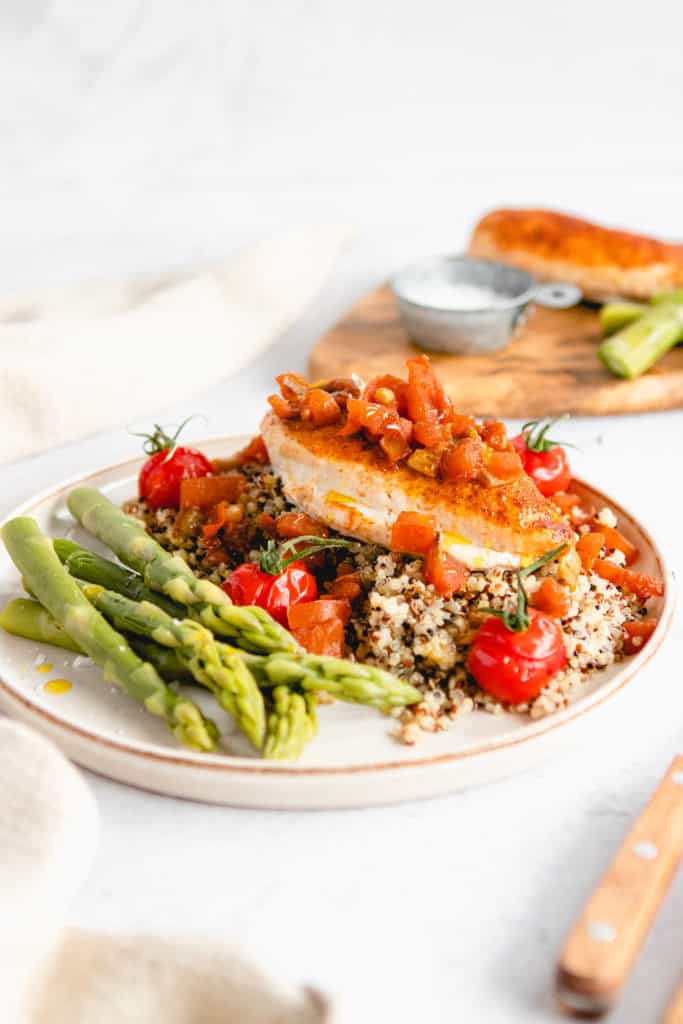 Plated Easy Air Fryer Tuscan Chicken with creamy sun-dried tomato garlic sauce and fresh herbs.