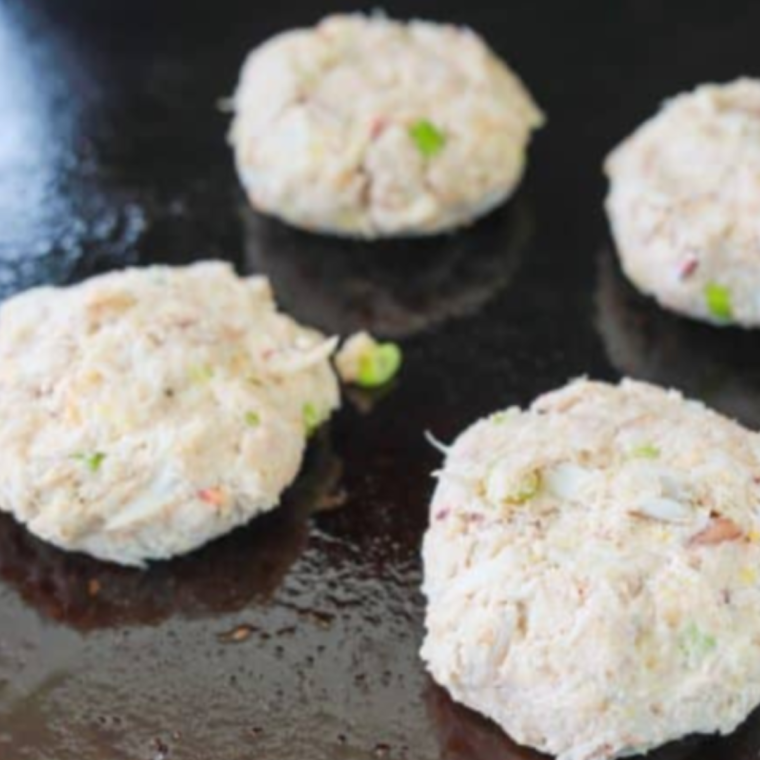 Hands shaping a crab cake patty before chilling it in the fridge