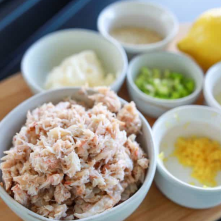 Ingredients for Blackstone crab cakes: lump crab, egg, mayonnaise, panko, Old Bay, green onion, and lemon