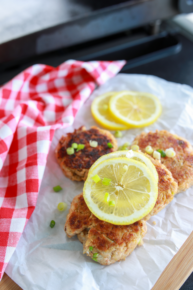 Golden crispy crab cakes cooking on a Blackstone griddle with buttery seared edges and fresh seafood texture