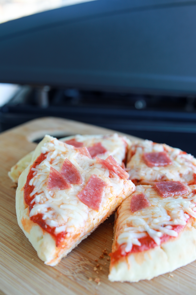 Blackstone pepperoni pizza with crispy crust, melted mozzarella, and pepperoni slices cooking on a hot griddle.
