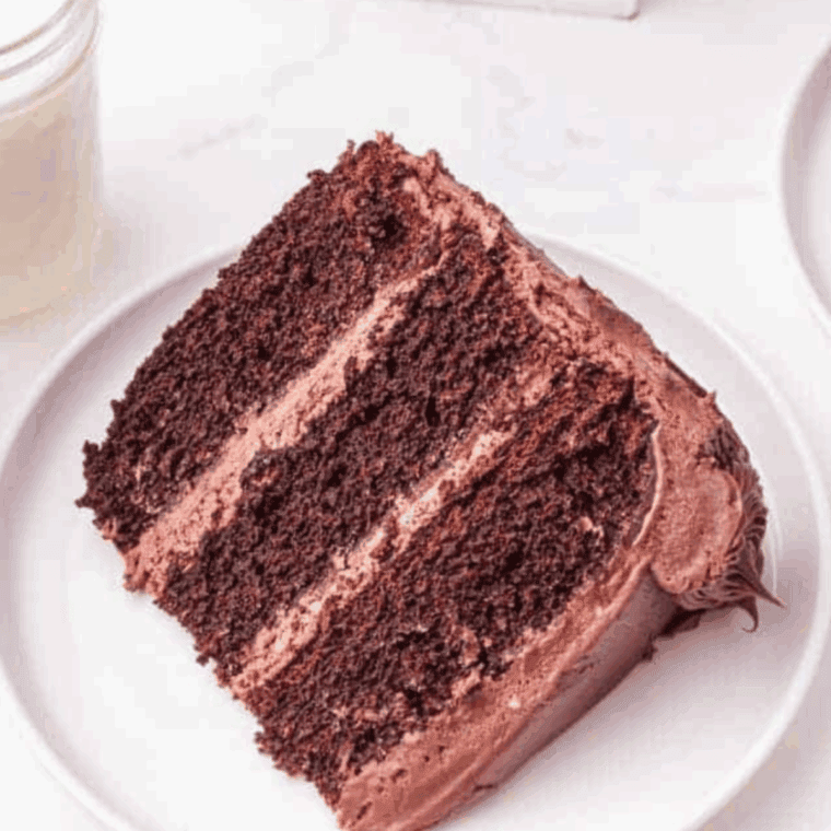 Slice of Cheesecake Factory Linda’s Fudge Cake with rich chocolate layers and creamy frosting on a dessert plate.