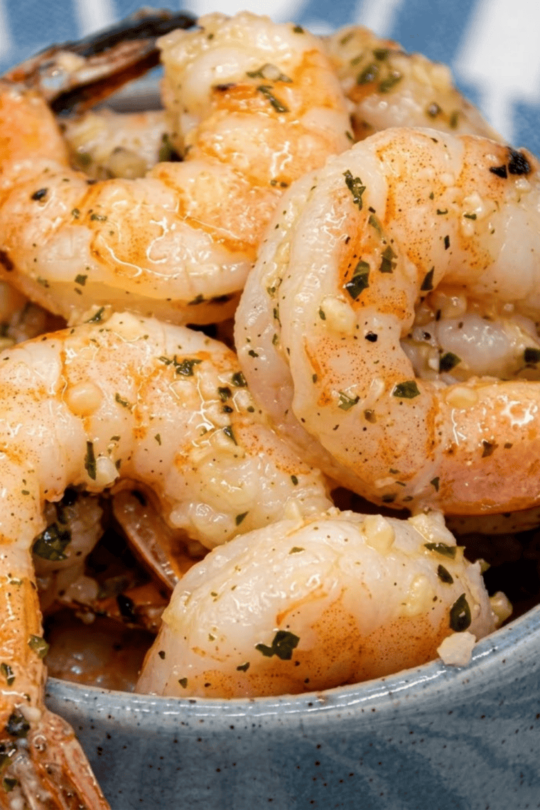 Crispy air fryer shrimp coated with garlic and parmesan, served on a plate.