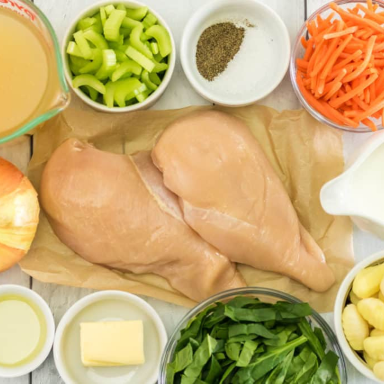 "Ingredients for Instant Pot Chicken Gnocchi Soup laid out on a countertop, including chicken, gnocchi, carrots, and celery."